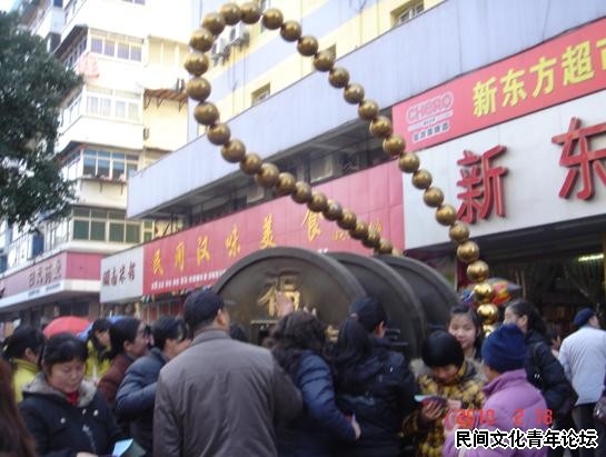 连路边的“钱”雕塑都成了香饽饽，人人都来摸一摸